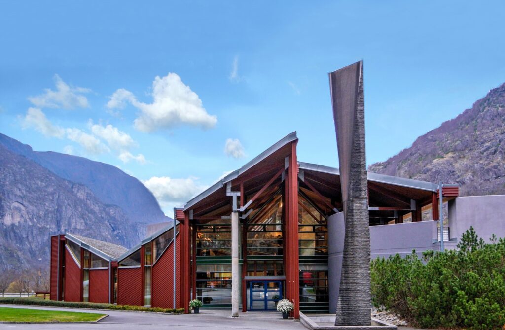 Norwegische Naturentrum. Rotes Haus mit Bergen im Hintergrund