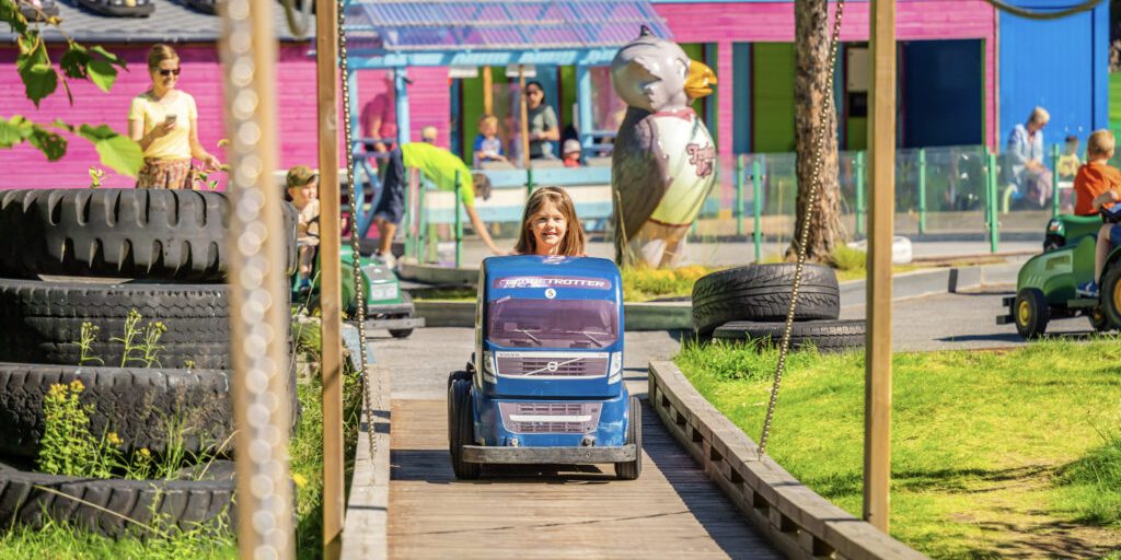 Mikkelparken_04 Young girl in an amusement park driving a mini car.